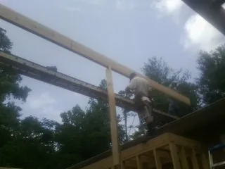 Carpenter setting a ridge beam over a new addition frame — Ice Dam Removal by Roofing Brothers in Heppner