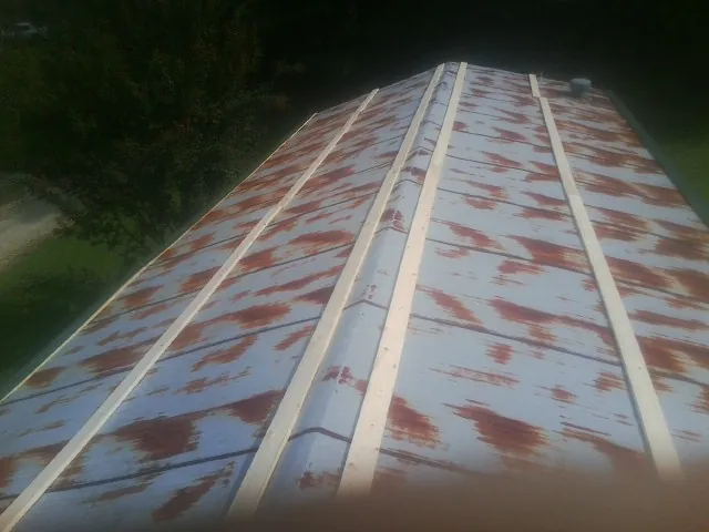 Rusted metal roof panels with new wood purlins before replacement — Storm Damage Roof Repair in Heppner by Roofing Brothers