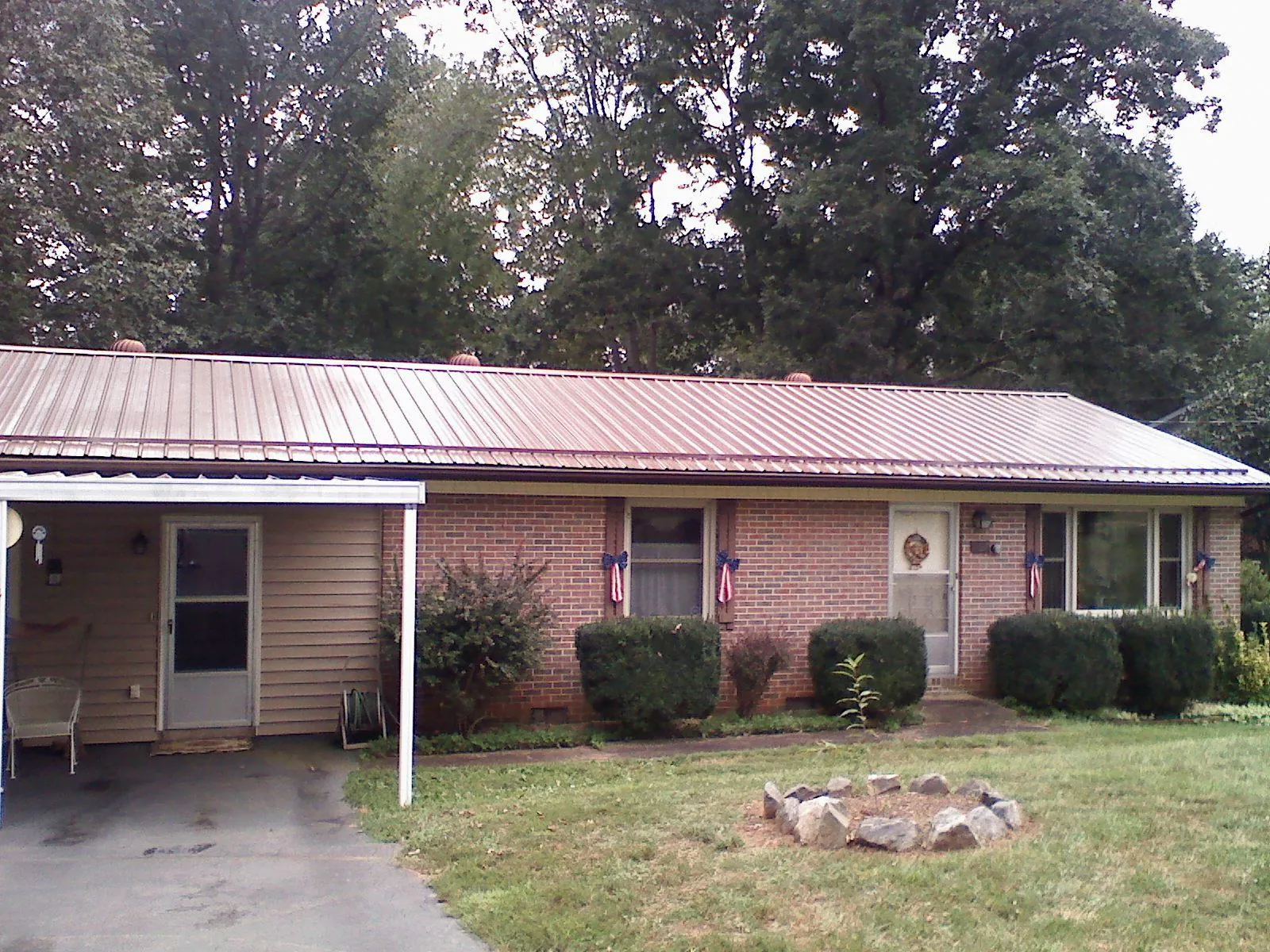 Bronze metal roof and carport on a brick ranch home — Roof Repair work by our crew in Heppner